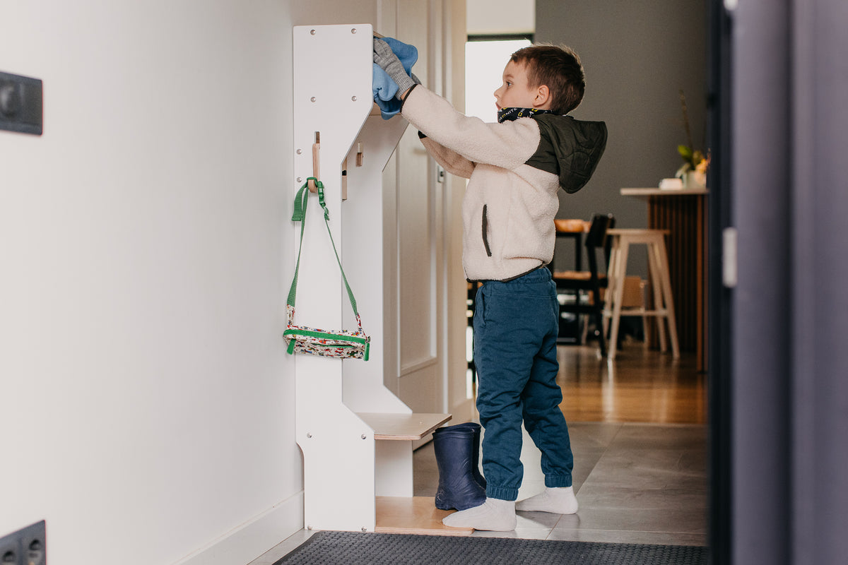 Barn nýtir fataskápinn sjálfstætt til að hengja upp jakka og tösku.