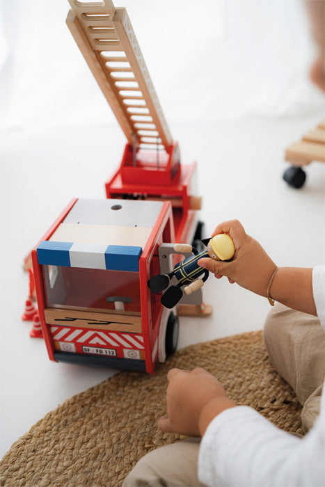 Nærmynd af barni að halda á slökkviliðsmanni við bílinn