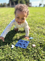 Barn að leika með Sílíkon púsl frá Small Foot úti á grasi