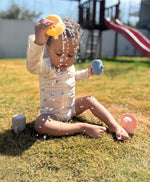 Barn úti að leika með sílíkon baðdýr og hella vatni úr gíraffa.