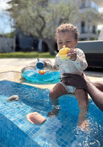 Barn að leika með sílíkon baðleikföngum við sundlaug, ljón og fíll í vatninu.