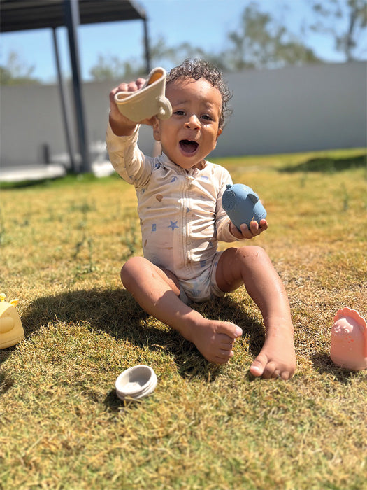 Barn úti að halda á sílíkon apa baðleikfangi.