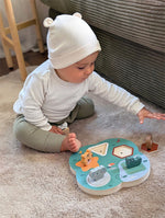 Lítið barn heldur á dýrafigúru úr 3D Safari hljóðpúsli.