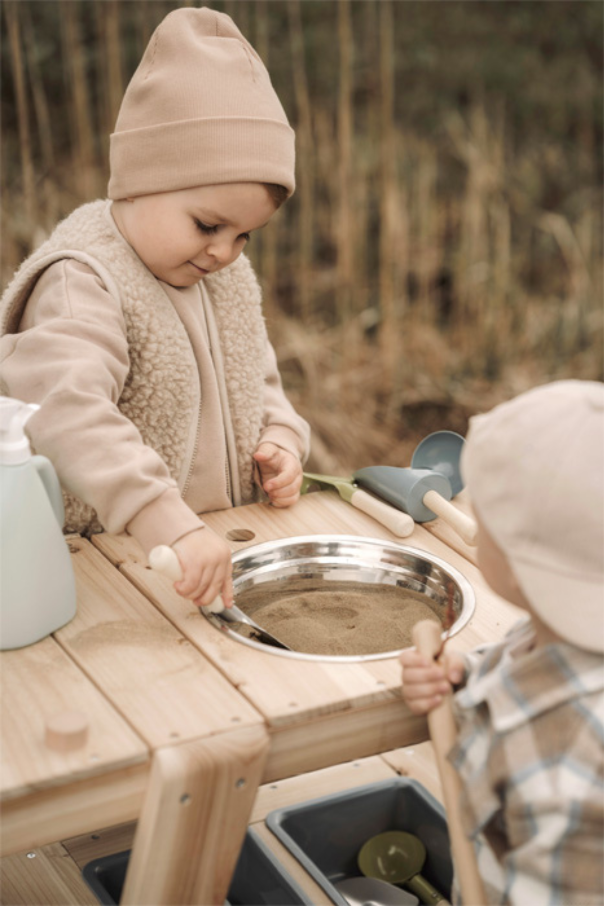 Börn að nota Skóflusett frá Small Foot í útileik með sandi og tréleikborði