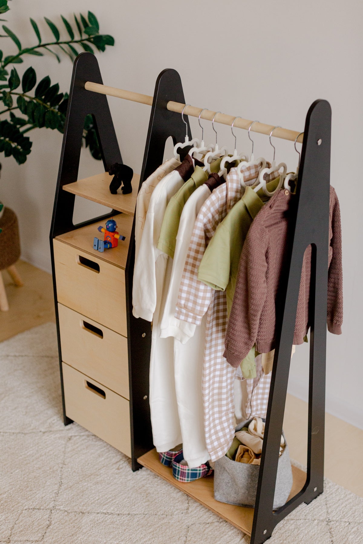 Montessori fataskápur með barnafötum á herðum í barnaherbergi