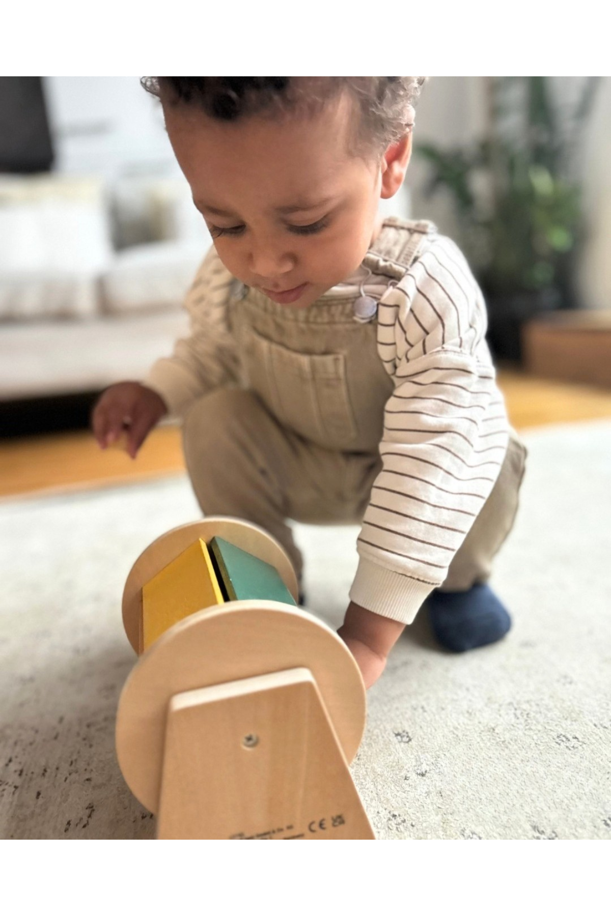 Barn að leika með Montessori tromlu – viðarleikfang sem styður hreyfiþroska.