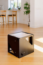 Svart 2in1 Cube sett á parketi í björtu rými