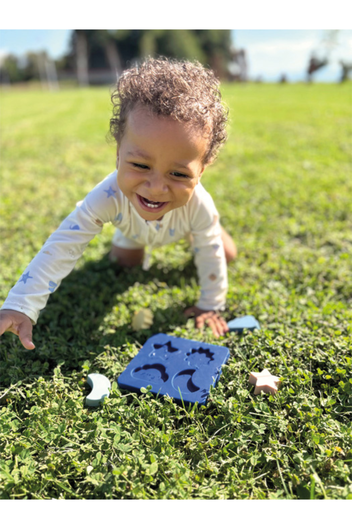 Barn að leika með Sílíkon púsl frá Small Foot úti á grasi