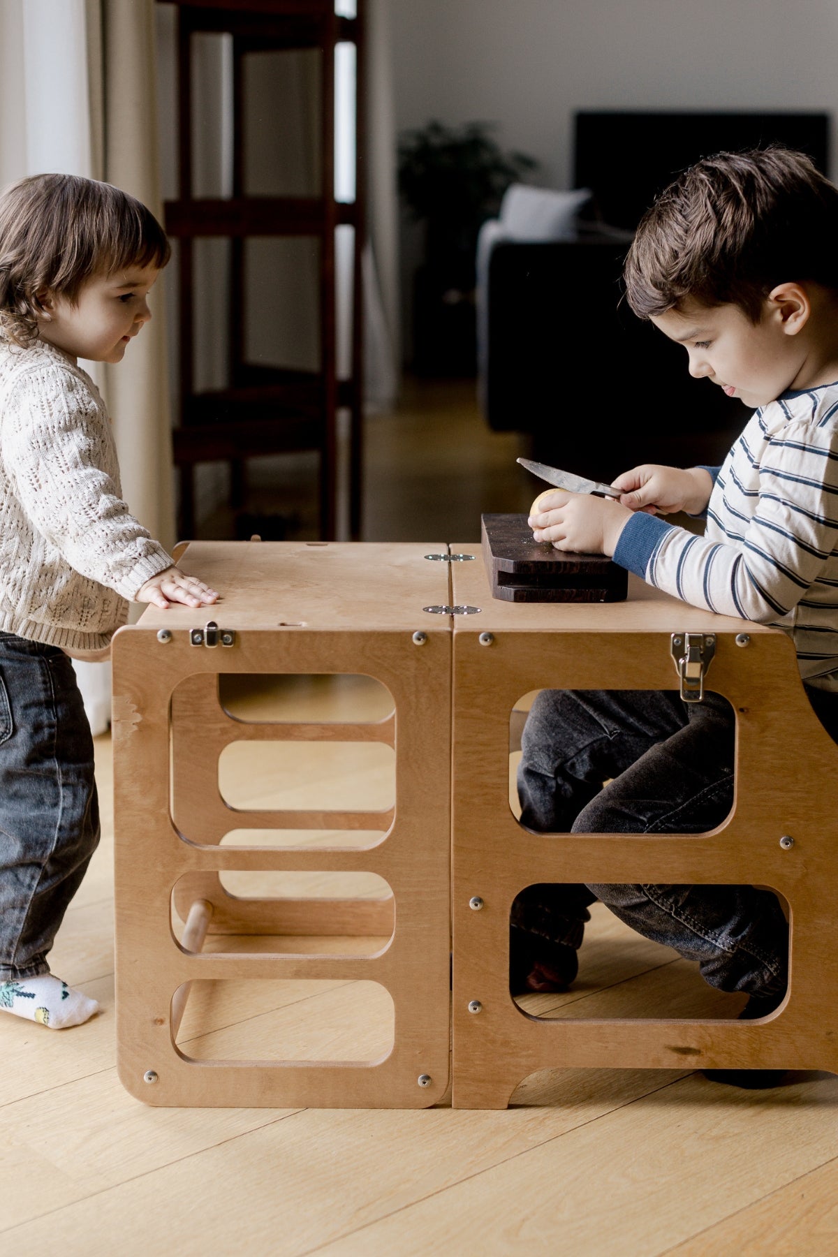 Systkyn að nota Mid-Century 2in1 hjálparturn í Scandinavian natural, turninum er breytt í bekk með borði.