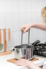 Barn stappar kartöflur með Kiddikutter kartöflustappara úr beyki og stáli.