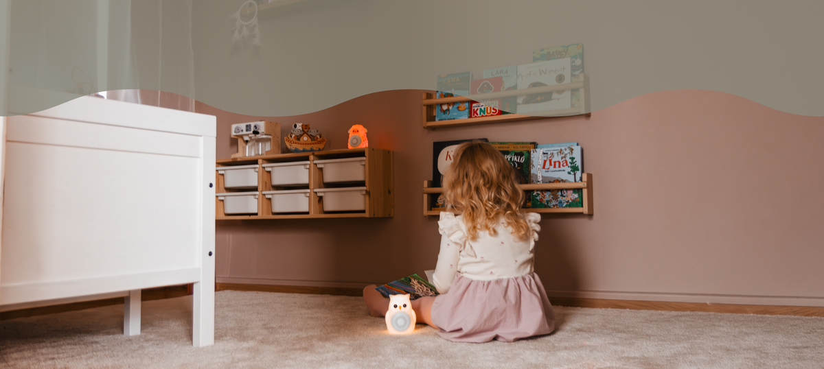 Barn að leika sér í barnaherbergi með Montessori leikföng og White Noise tæki