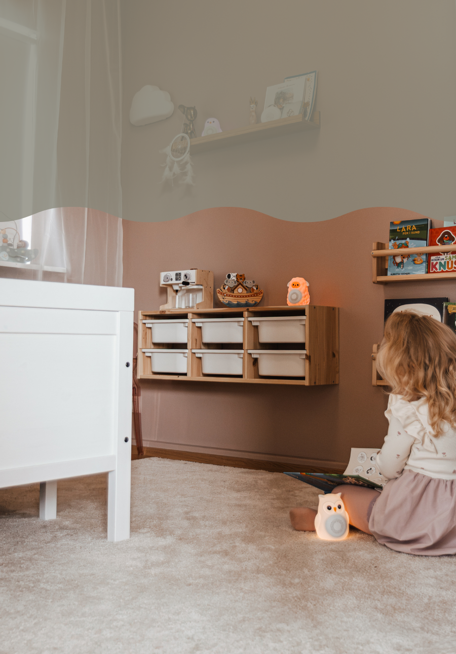 Barn að leika sér í barnaherbergi með Montessori leikföng og White Noise tæki