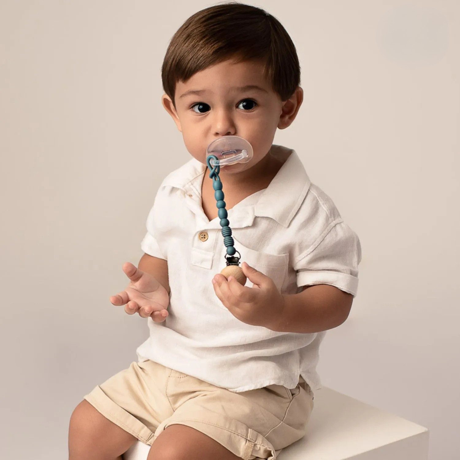 Barn með Blátt snudduband fest á snuð