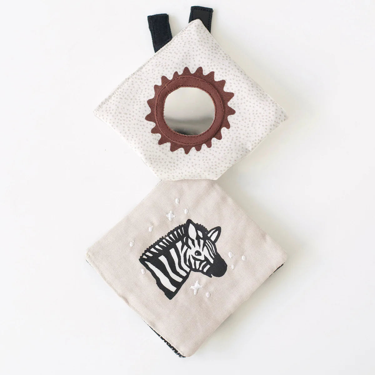 Baby teething ring and soft book with zebra design on a white background