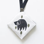 White pouch with a black bear illustration on a white background