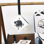 Small pouch with bear design hanging on a wooden rack