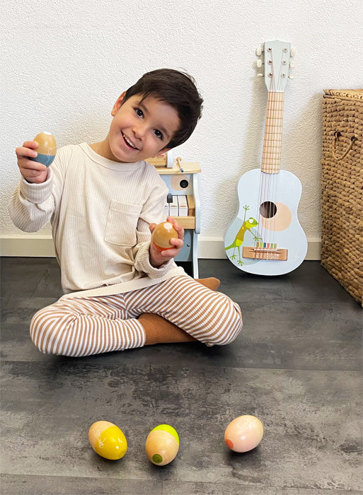 Barn að leika sér með egg hristara úr við – Small Foot tónlistarleikfang