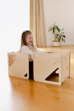 Barn að nota 2in1 Cube sett sem stól og leikborð