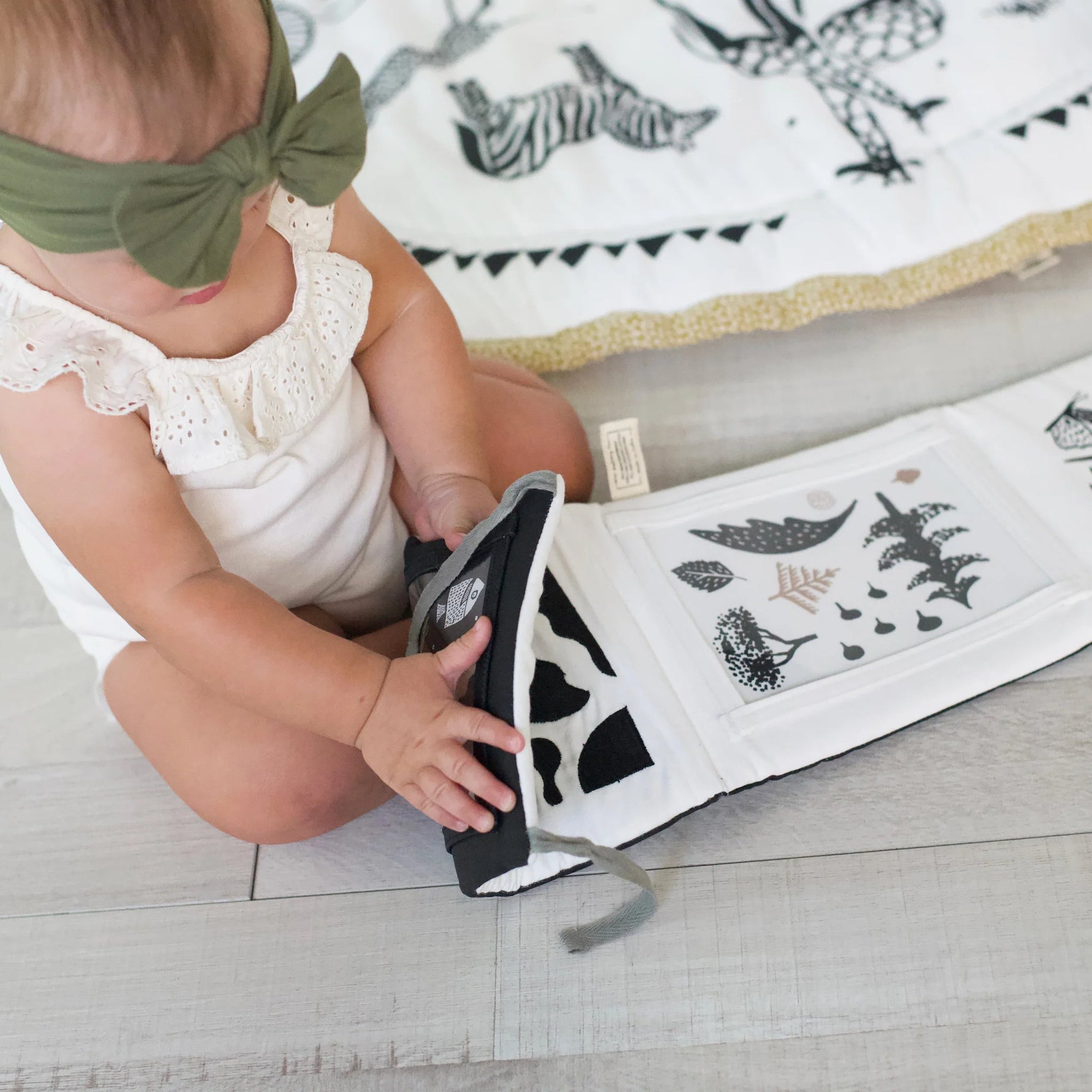 Barn leikur með Tummy Time Gallery og skoðar fallegar myndir