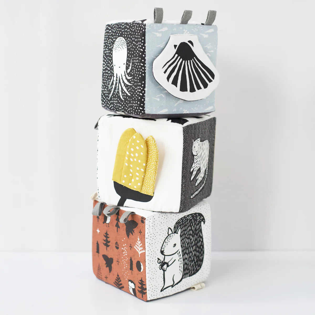 Stack of four fabric blocks with animal prints on a white background