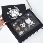 Tummy Time Gallery with white sea creature illustrations held by a hand on a light background